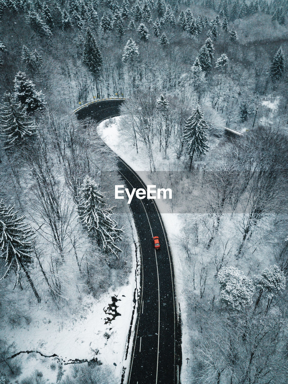 Aerial view of road amidst snow covered land during winter