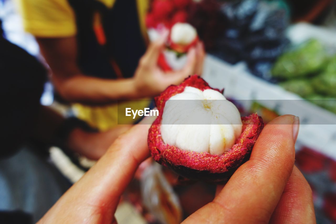 Cropped image of hand holding mangosteen