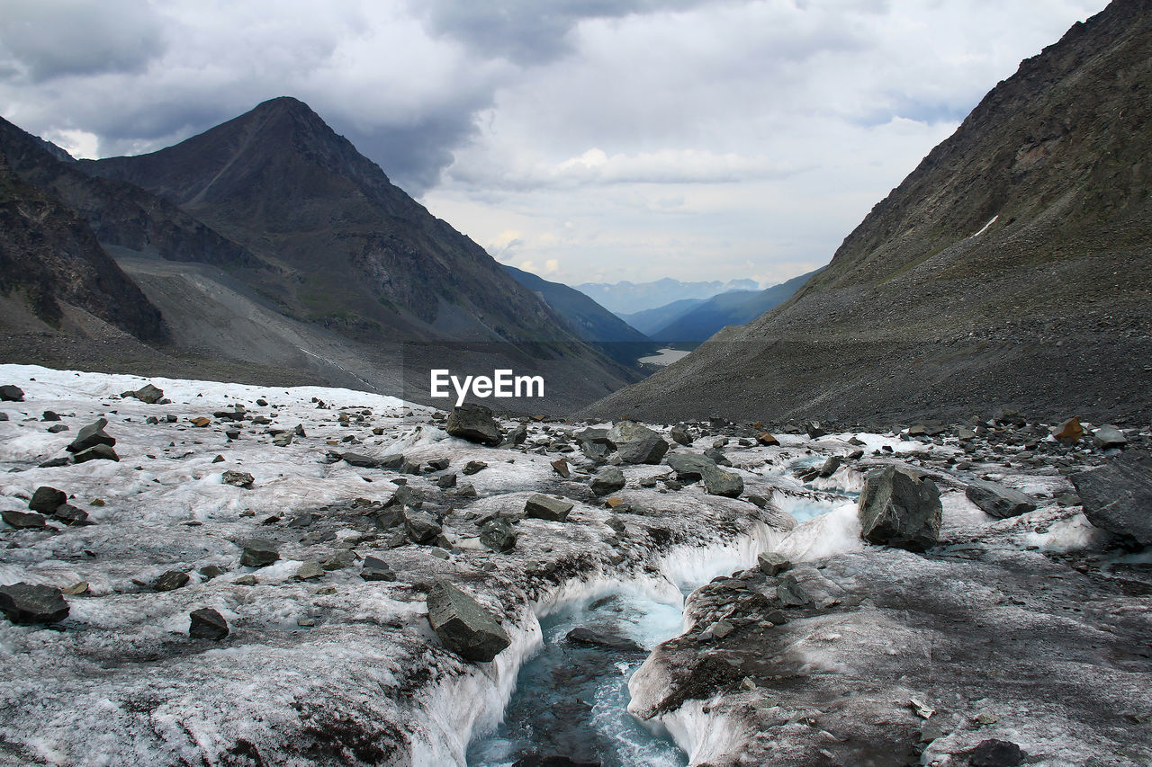 View from the glacier to the mountain valley in altai in cloudy weather, the sky with clouds