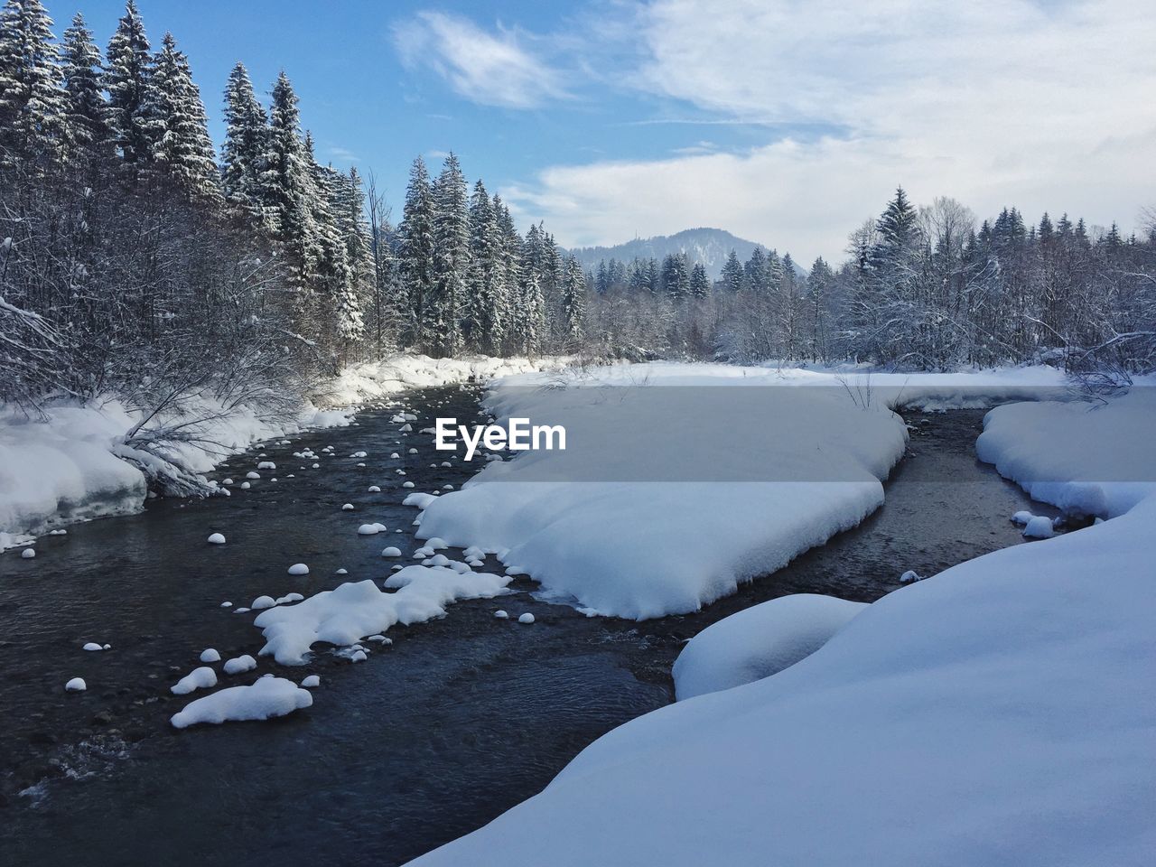 Frozen river against sky during winter