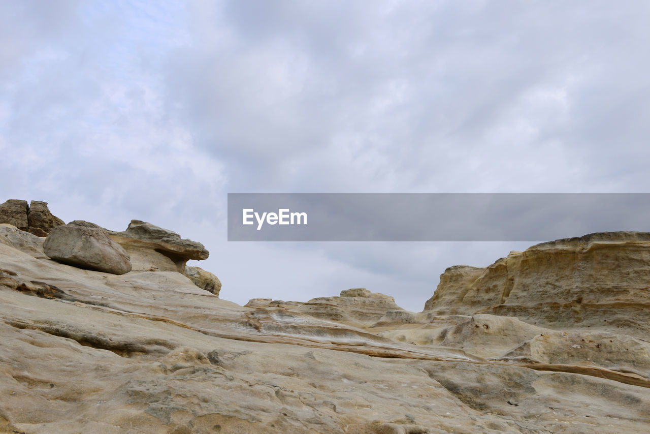 LOW ANGLE VIEW OF ROCK FORMATION ON LAND AGAINST SKY