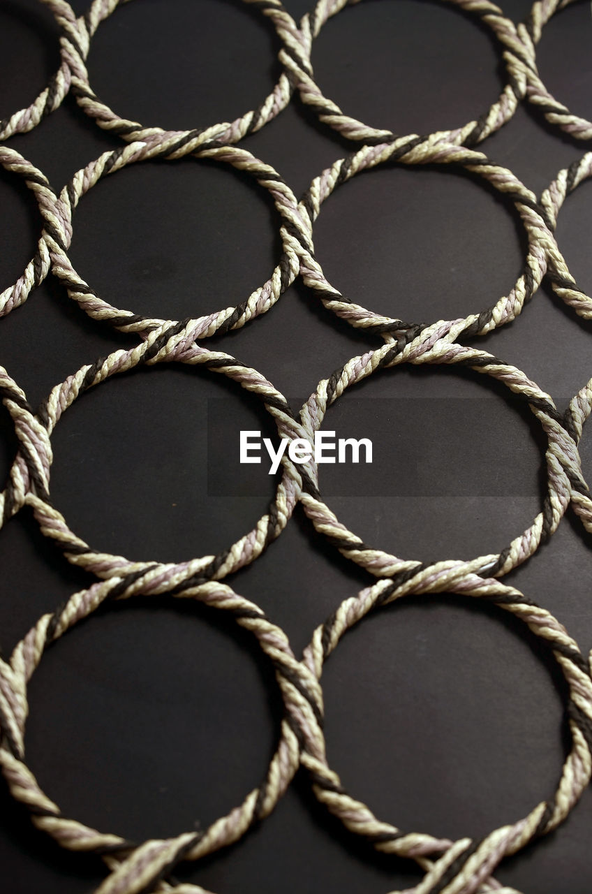 Close-up of patterned ropes on black background