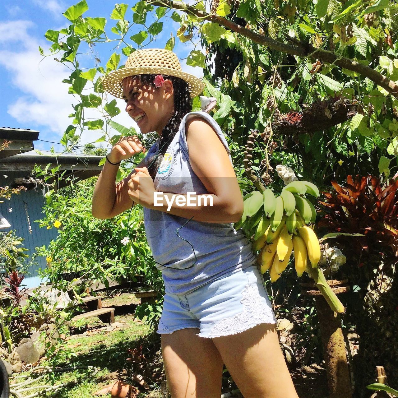 Tilt shot of woman standing against tree