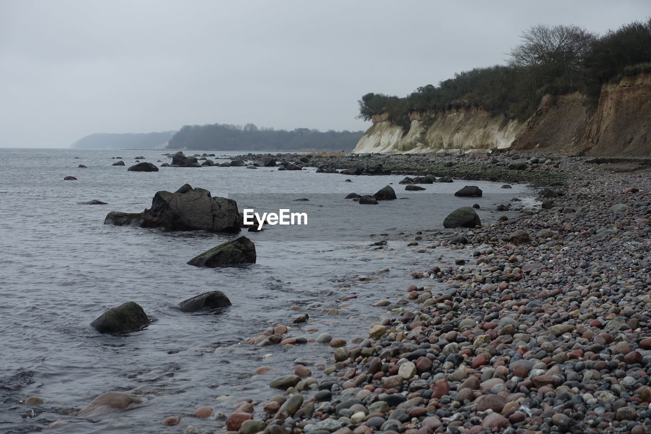 Rocks on beach against sky