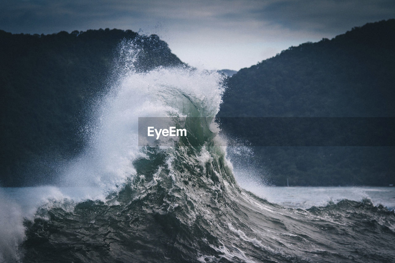 Scenic view of sea waves splashing against sky