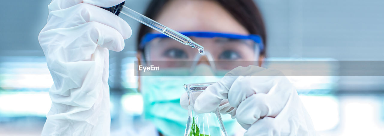 Close-up of female scientist experimenting in laboratory