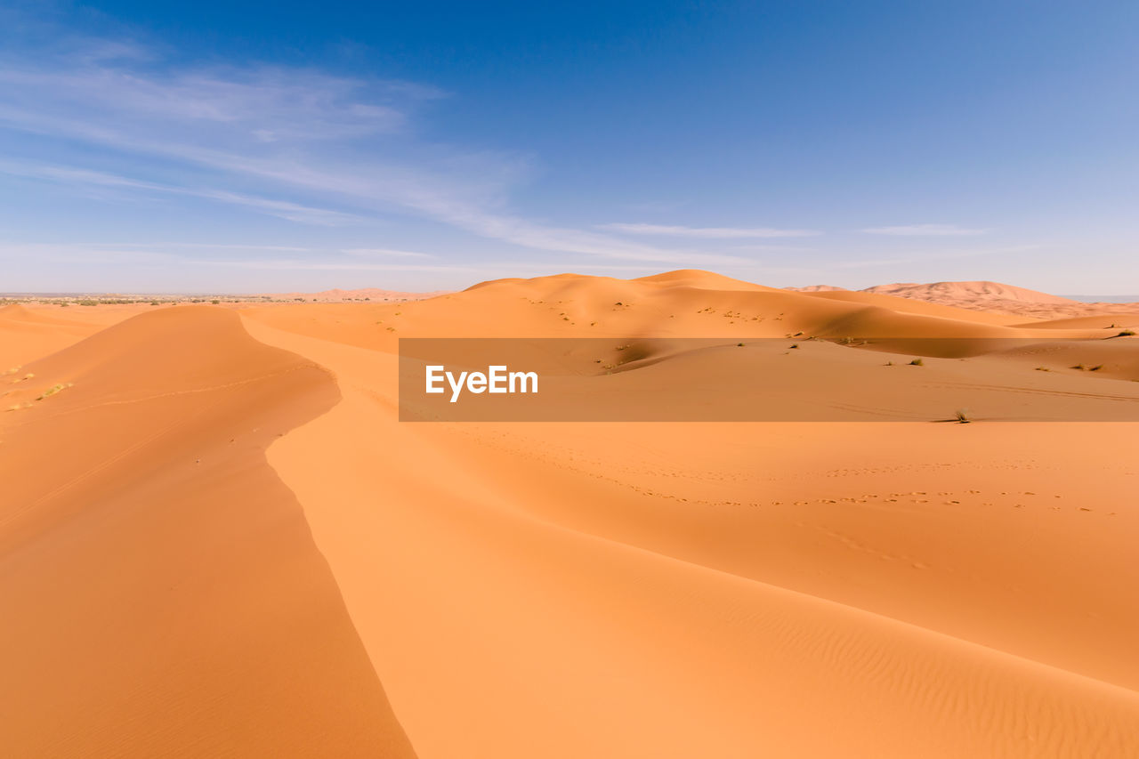 Sand dunes in desert against sky