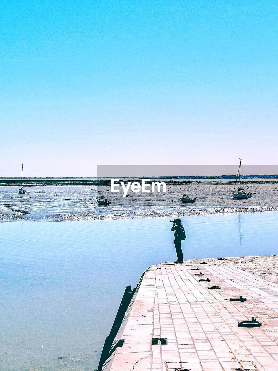 Man photographing sea against sky