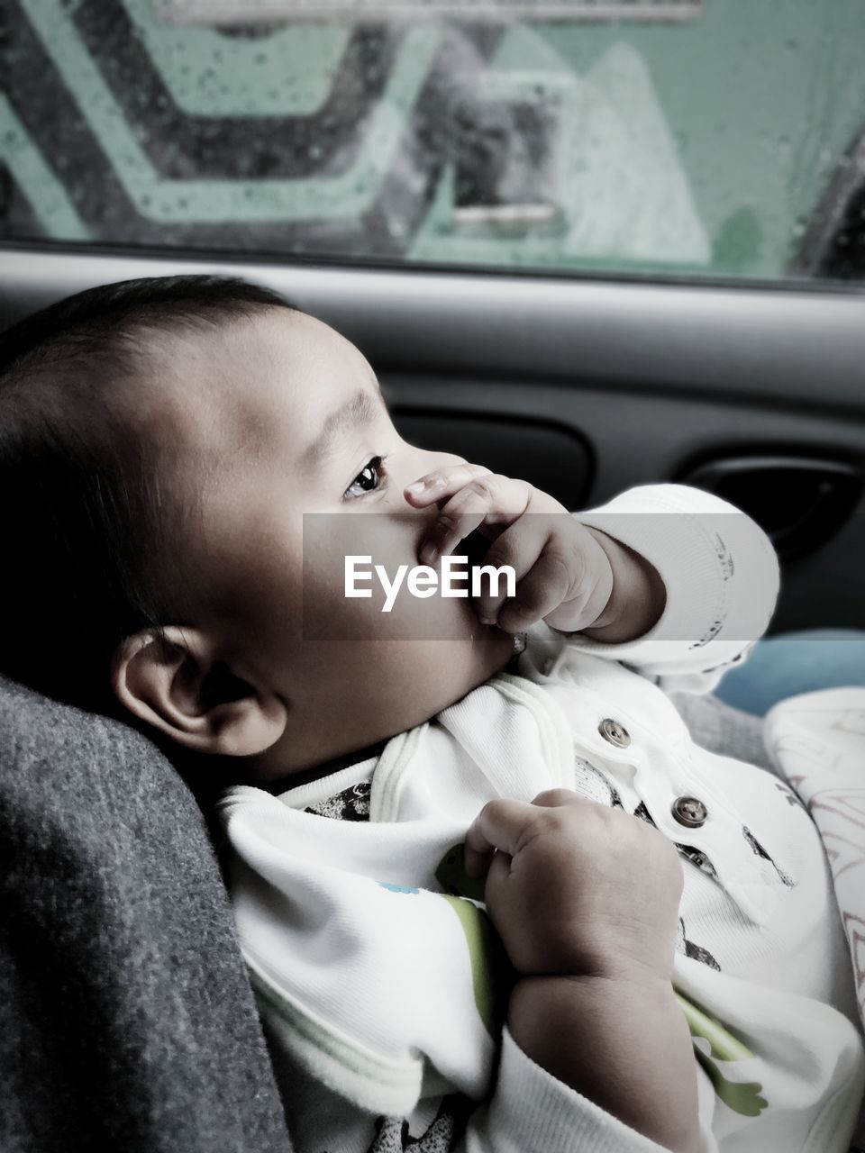 Close-up of cute baby girl sitting in car