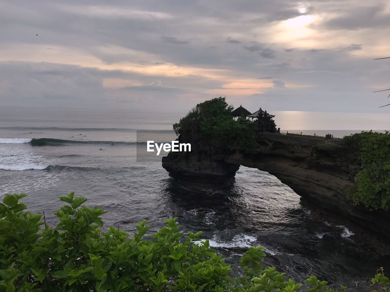 ROCK IN SEA AGAINST SKY DURING SUNSET