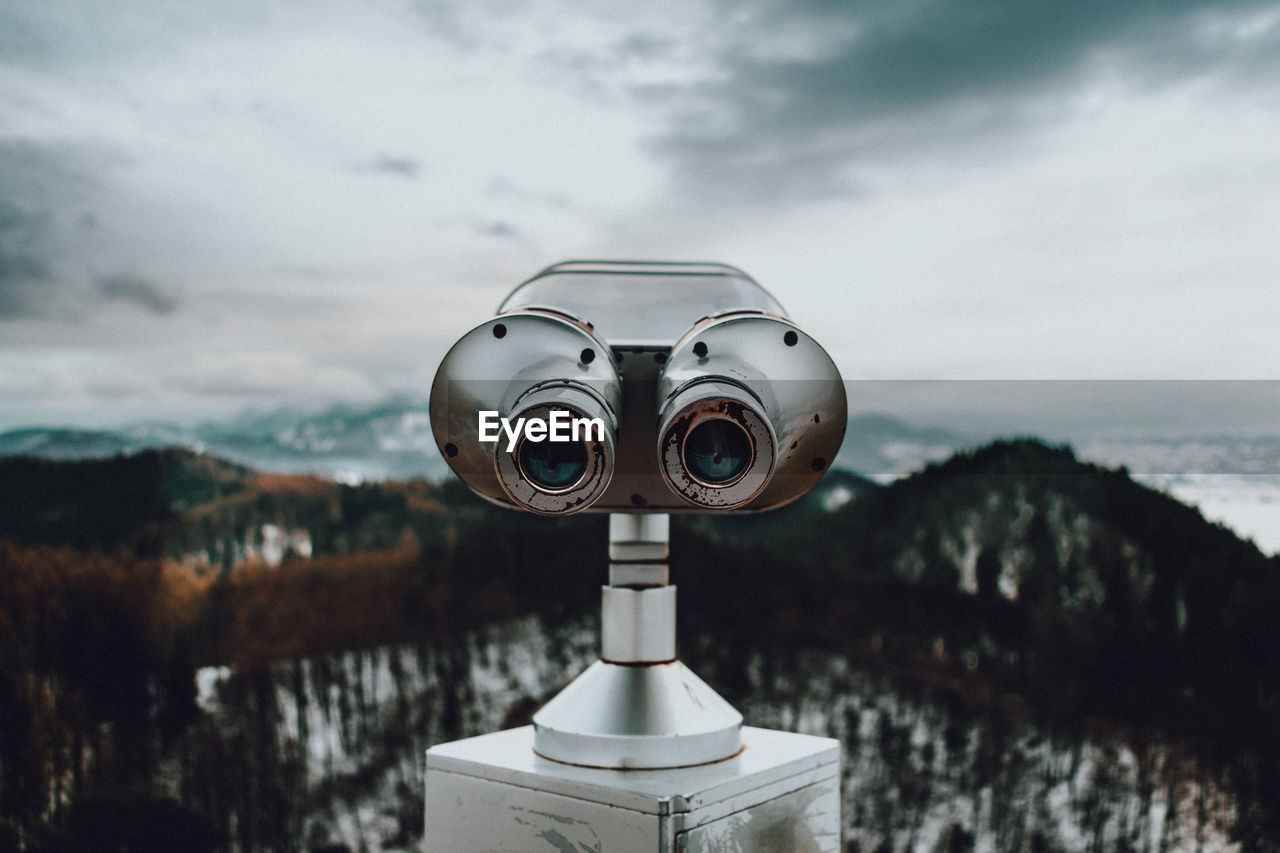 Close-up of coin-operated binoculars against sky