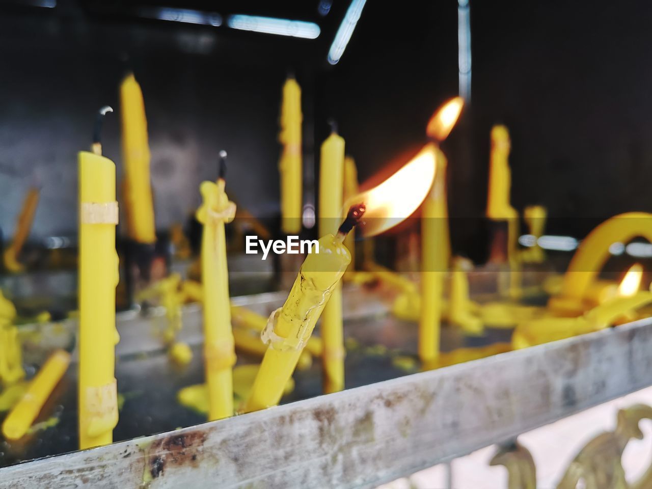 Close-up of lit candles on temple