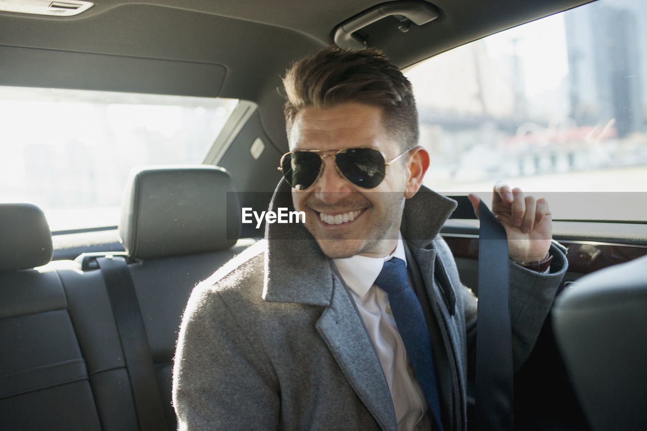 Young businessman in car service limousine