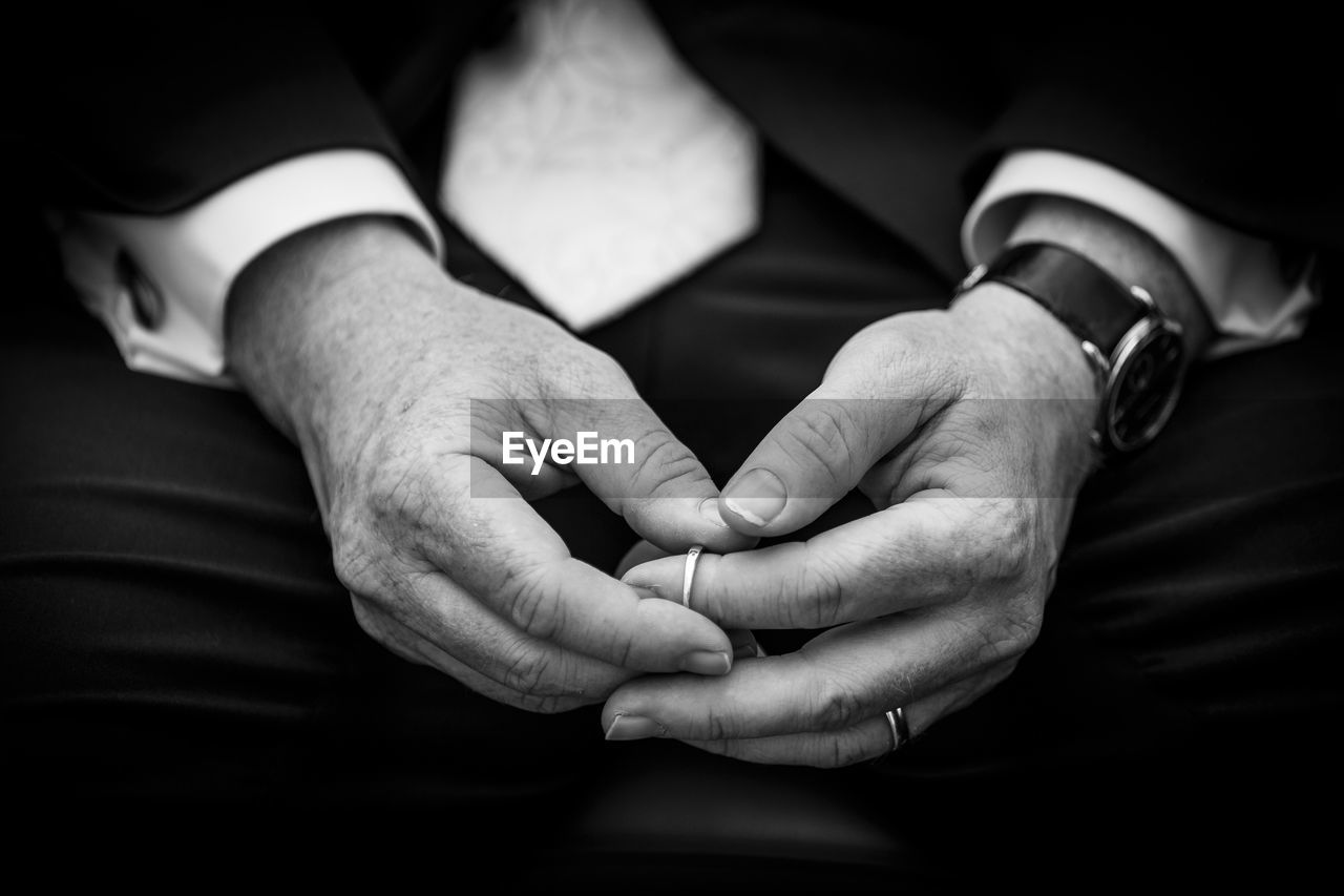 Midsection of man wearing ring while sitting indoors