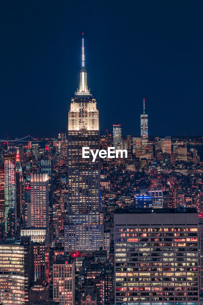 ILLUMINATED CITY BUILDINGS AT NIGHT