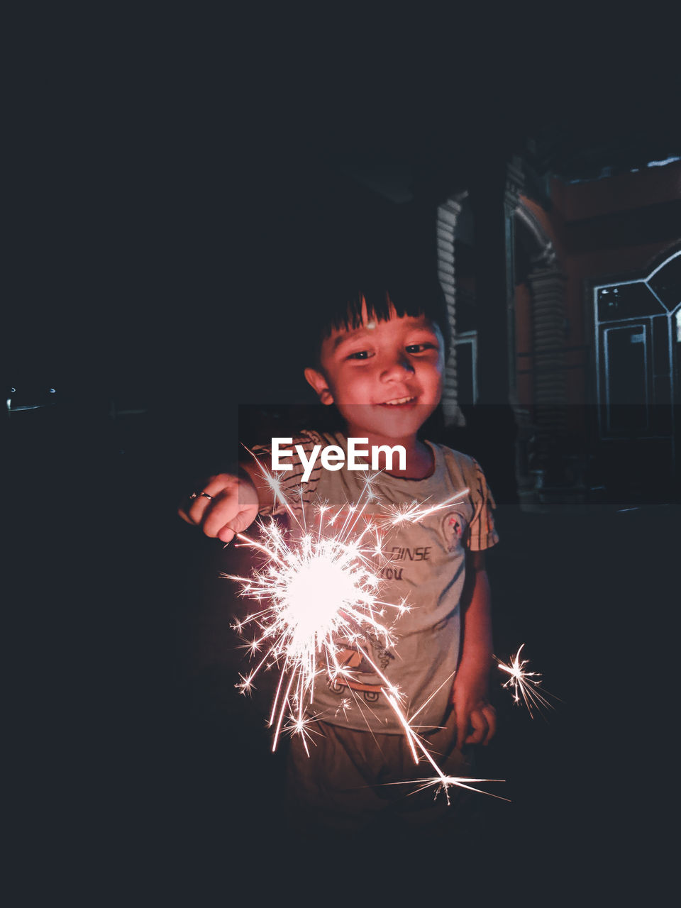 Full length portrait of smiling boy at night