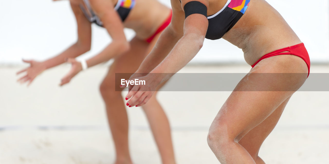 Low section of women playing beach volleyball