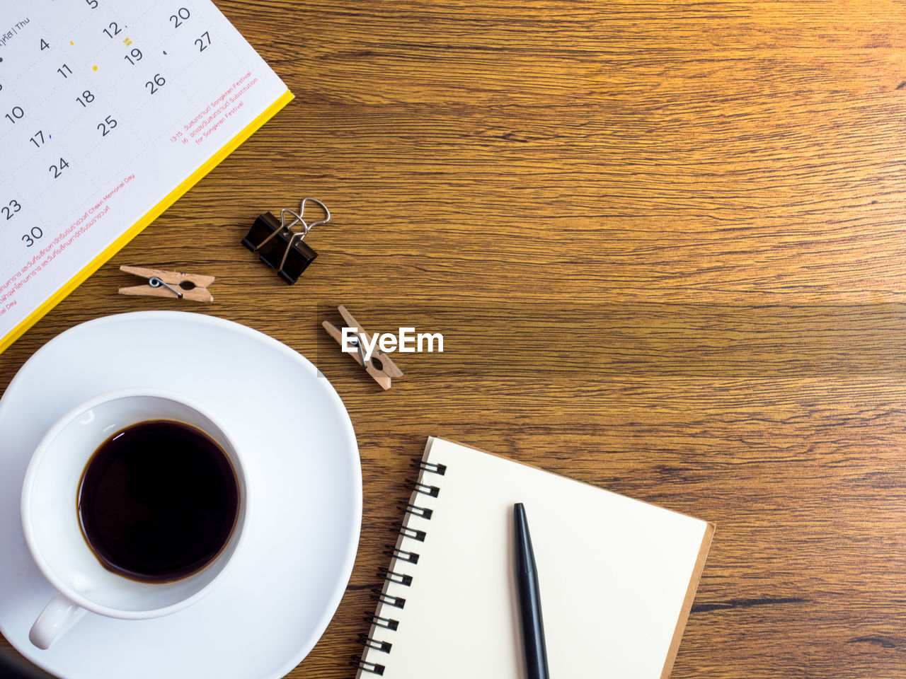 HIGH ANGLE VIEW OF COFFEE CUP ON TABLE WITH OPEN