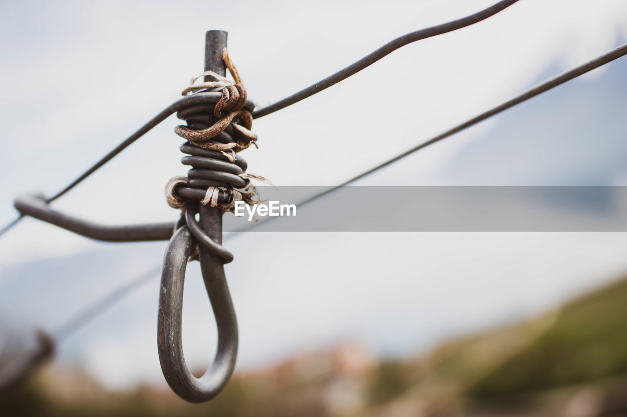 LOW ANGLE VIEW OF BARBED WIRE FENCE