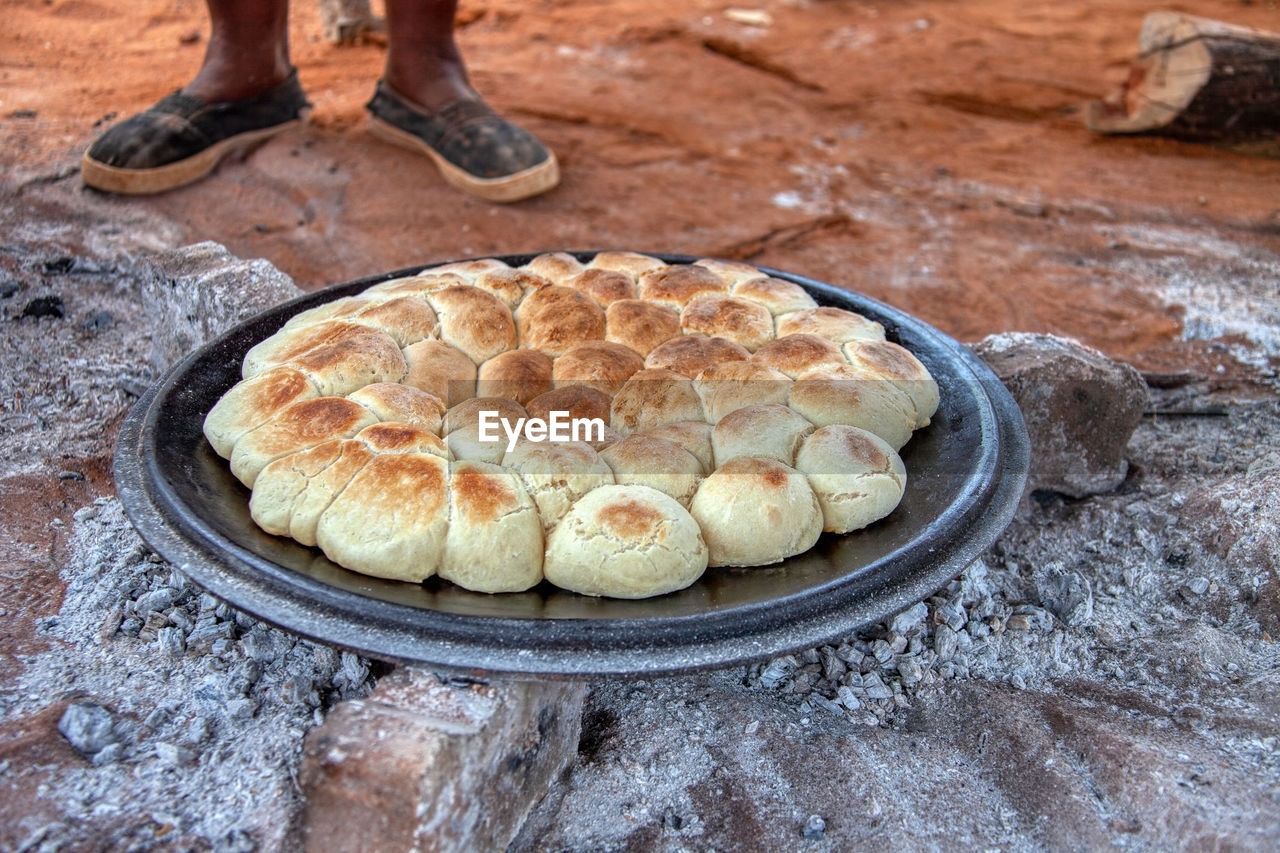 LOW SECTION OF PERSON STANDING WITH BREAD