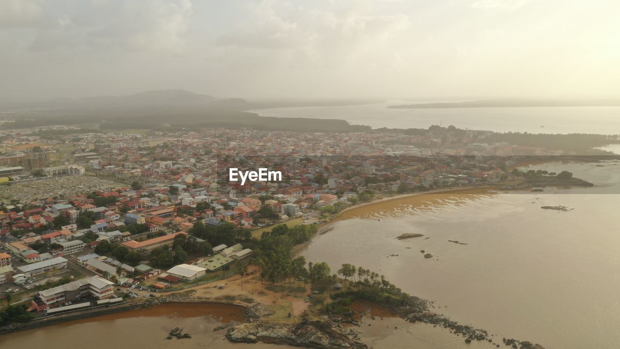 High angle view of buildings and sea against sky