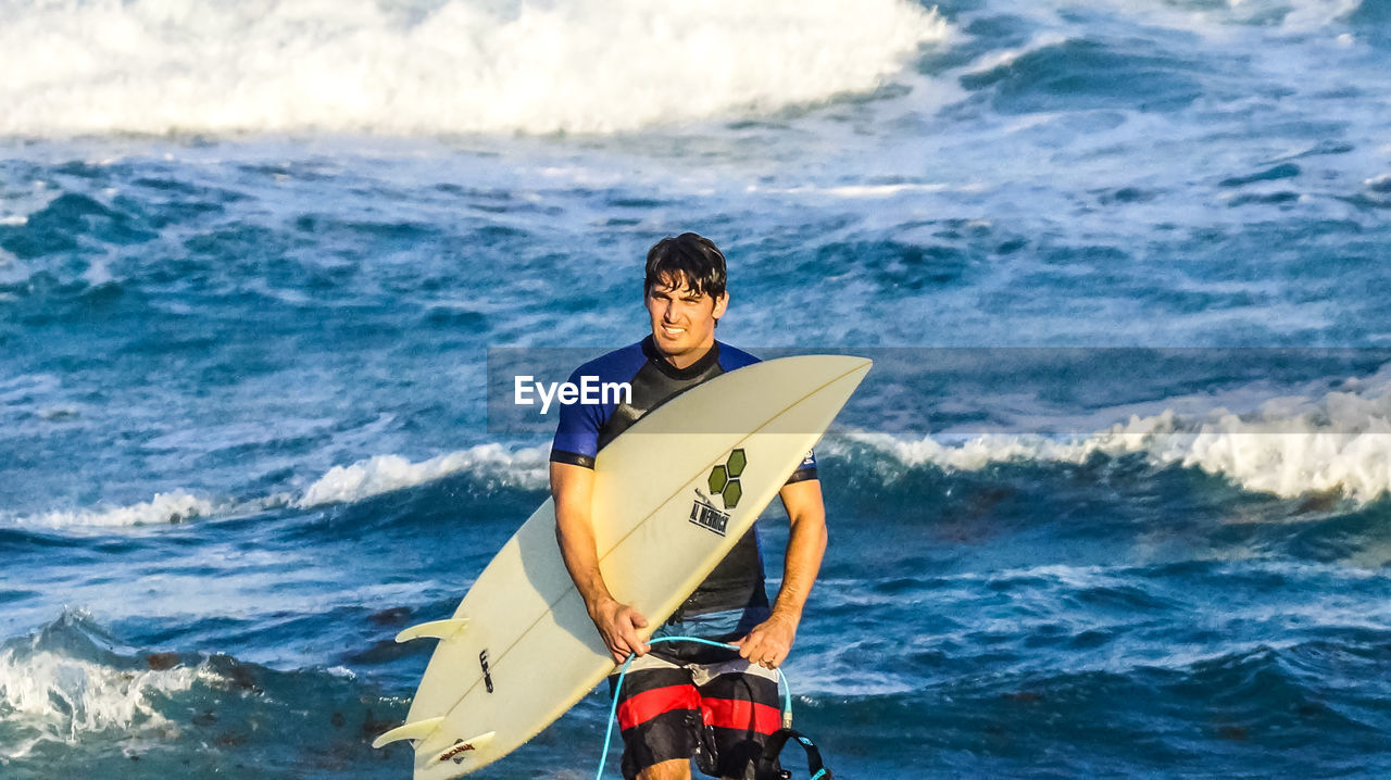 MAN STANDING IN SEA