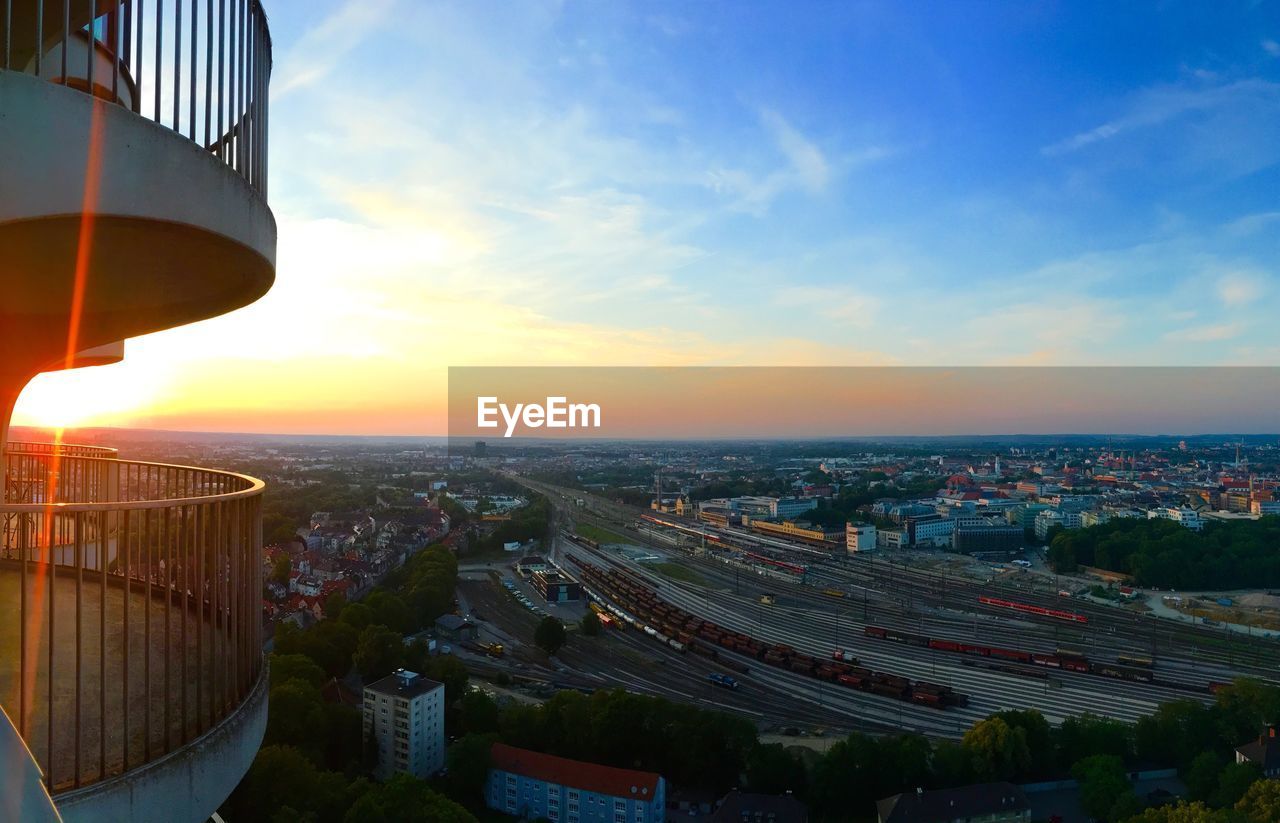 HIGH ANGLE VIEW OF BUILDINGS AGAINST SKY AT SUNSET