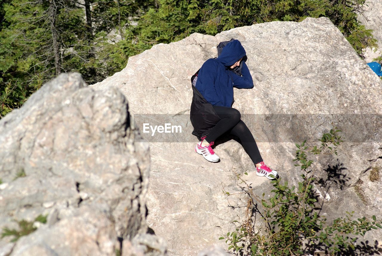 Woman sleeping on rock