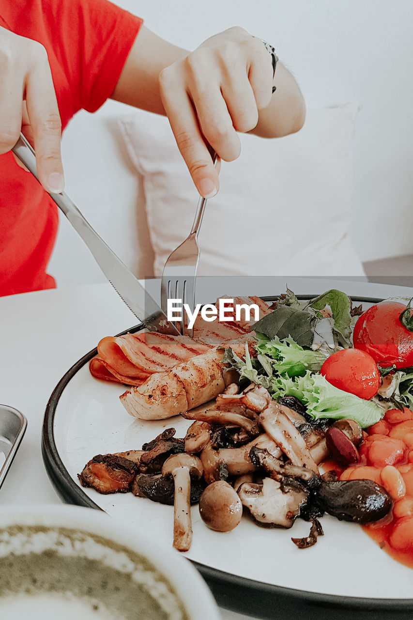 Midsection of woman eating food at restaurant