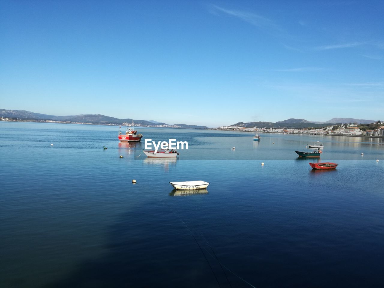 Sailboats on sea against clear blue sky