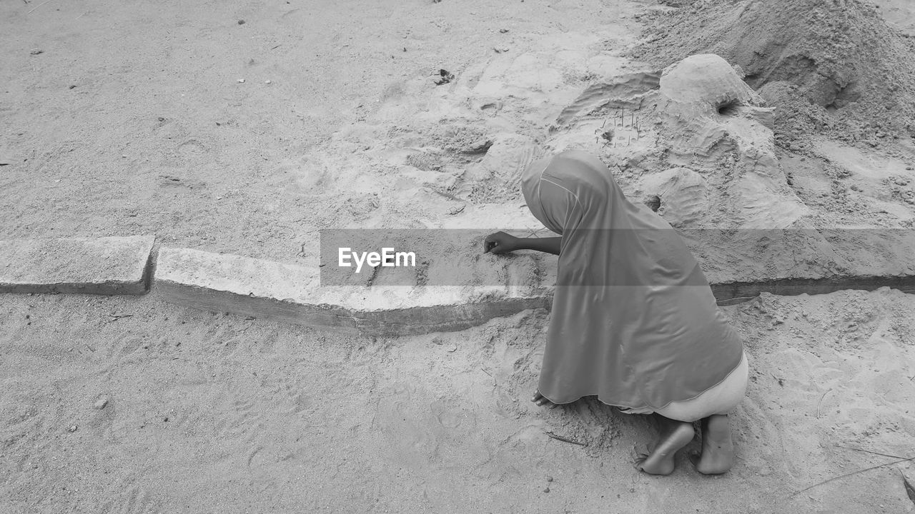 Rear view of child on sand at beach