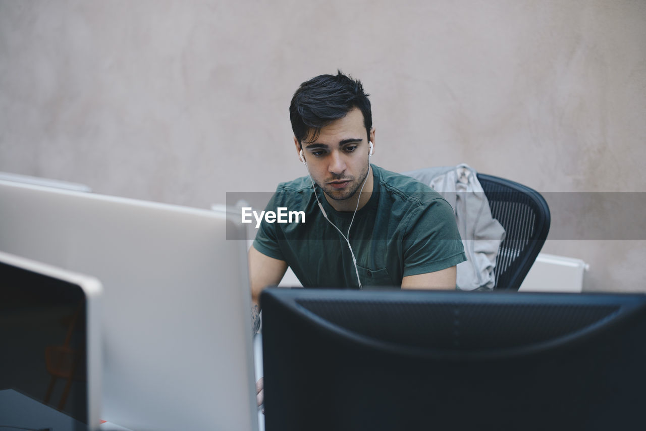 Male computer programmer using desktop pc in office