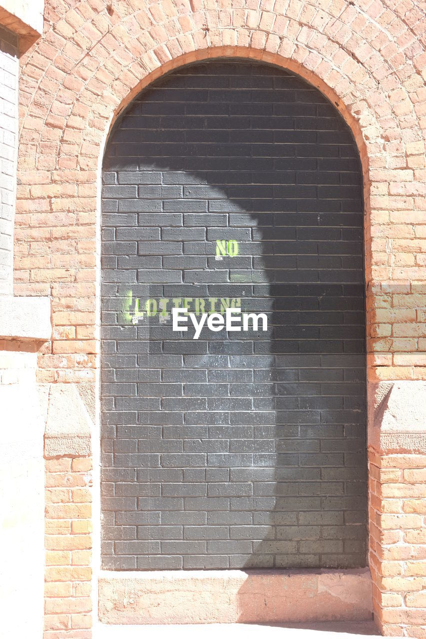 CLOSE-UP OF BRICK WALL WITH TEXT
