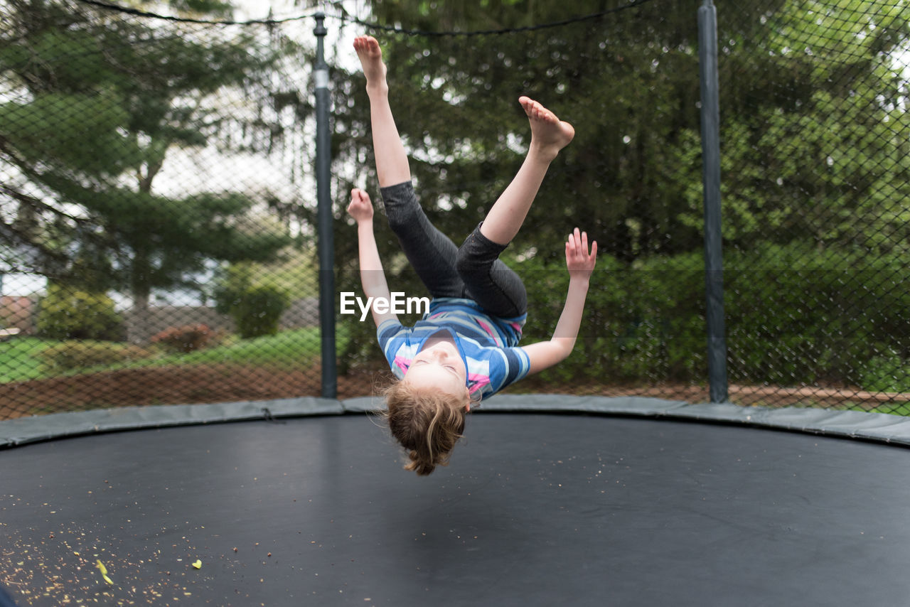 Playful girl jumping on trampoline at park