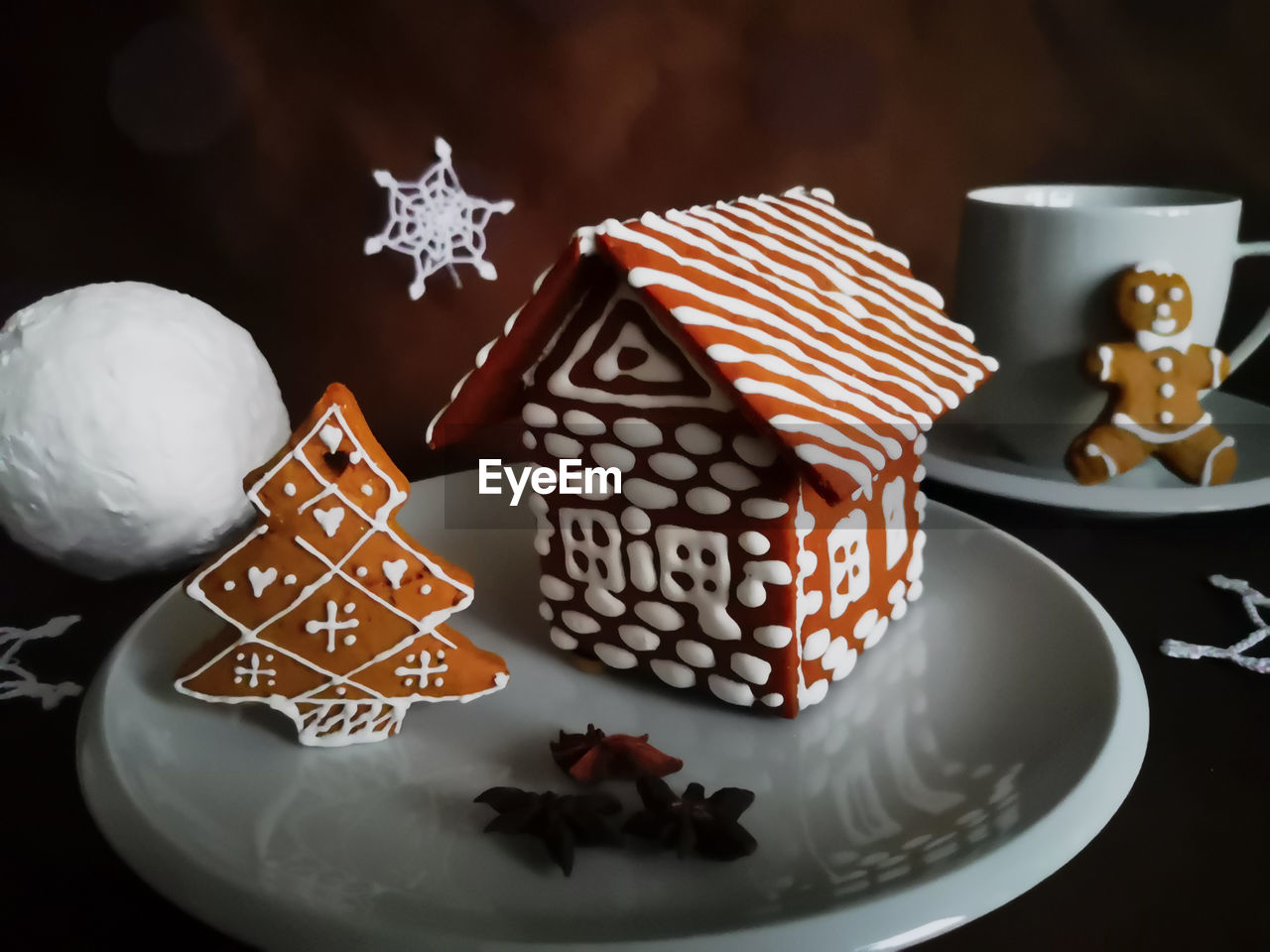 Gingerbread house and christmas tree decorated with white glaze in new year patterns 