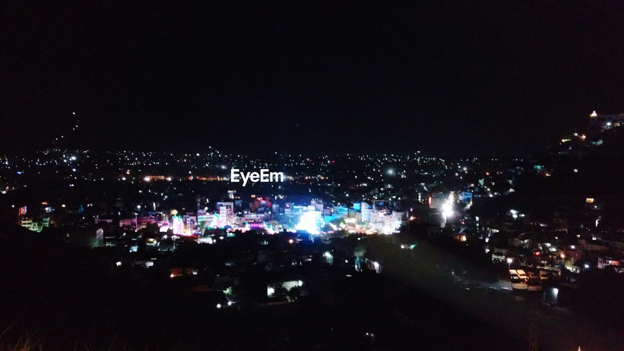 VIEW OF ILLUMINATED CITYSCAPE AT NIGHT