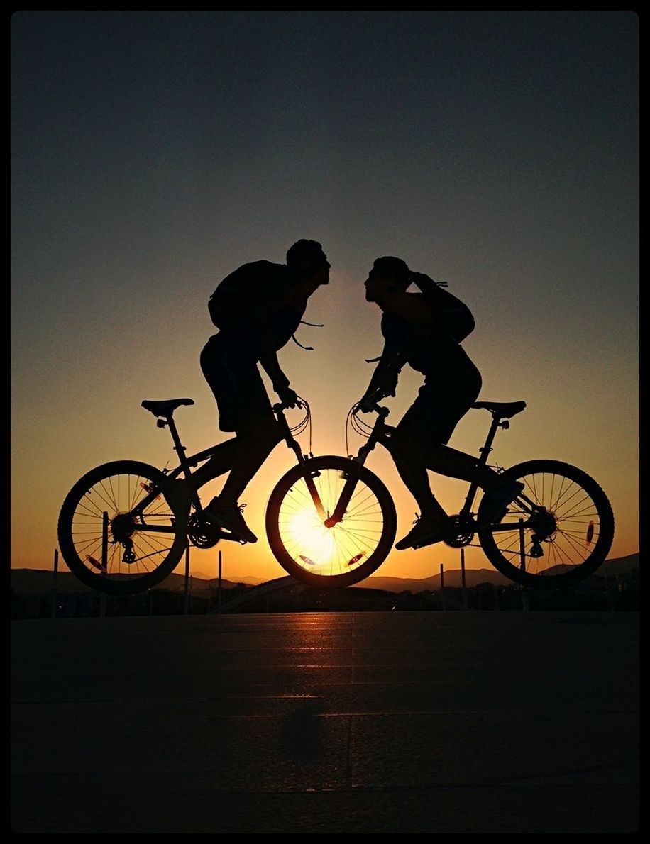 Silhouette of a couple on bicycles at sunset