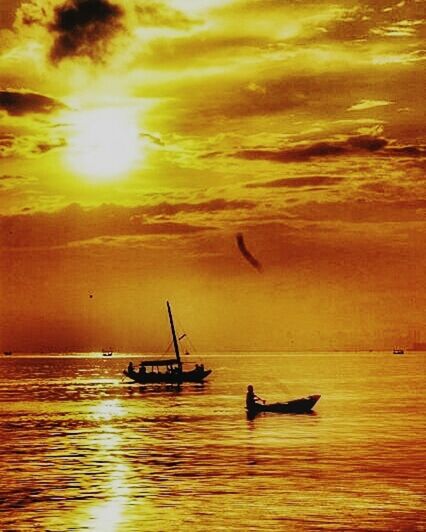 SILHOUETTE OF BOAT IN SEA AT SUNSET