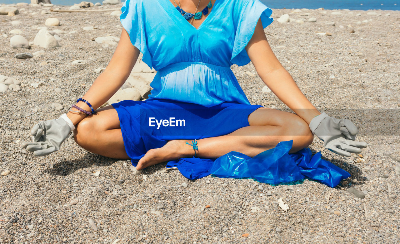 land, one person, beach, sand, blue, leisure activity, relaxation, nature, adult, lifestyles, women, sitting, sports, day, sunlight, full length, clothing, summer, trip, vacation, young adult, exercising, front view, casual clothing, outdoors, holiday, limb, photo shoot, sea, human leg, sky, sunny, person, female, water