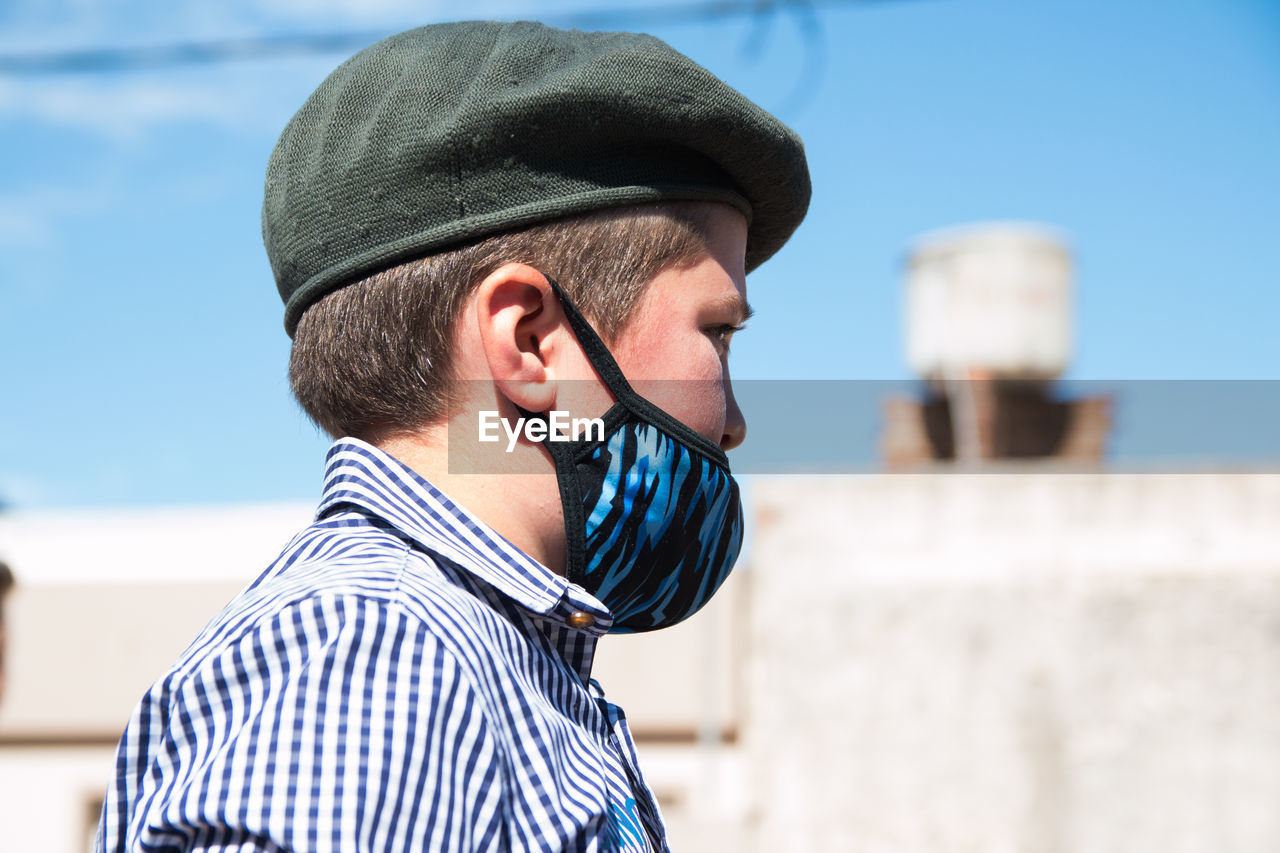 South american boy wearing face mask and traditional clothing