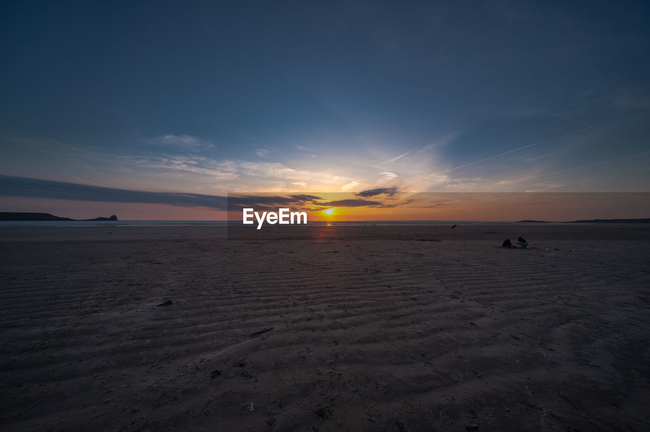 Scenic view of beach against sky during sunset