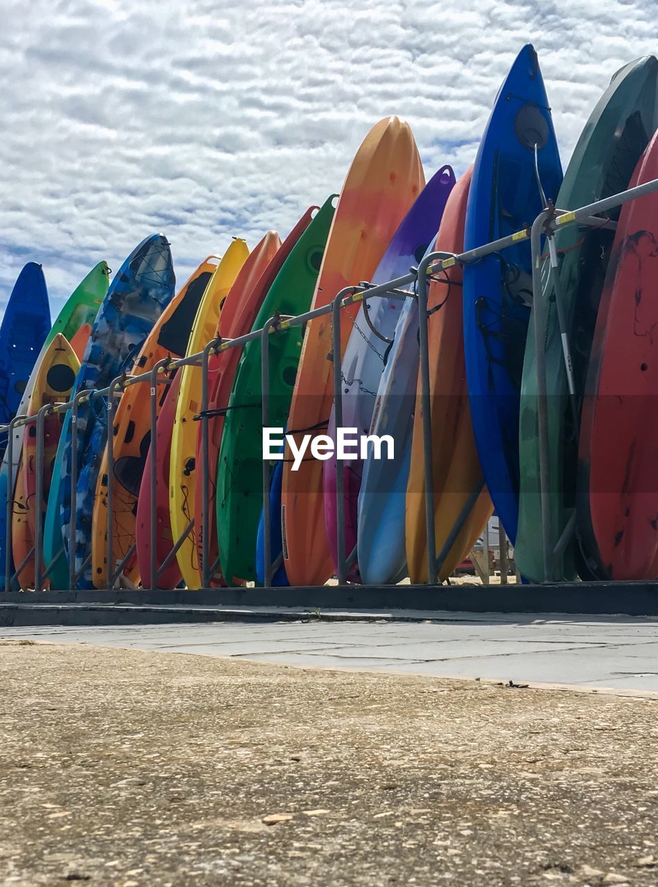Multi colored surfboards at beach against sky