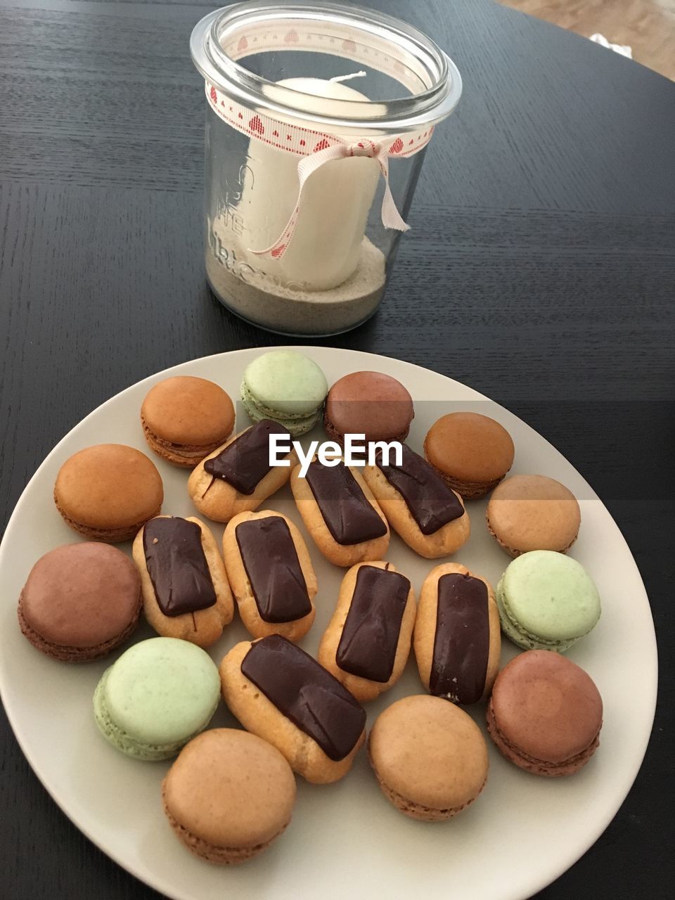 High angle view of eclairs and macarons on table