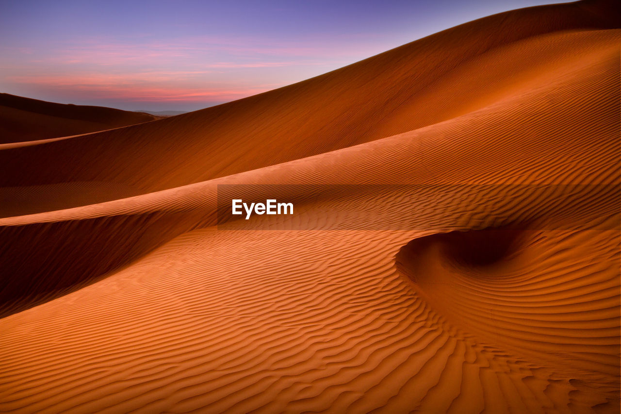 Scenic view of desert against sky during sunset