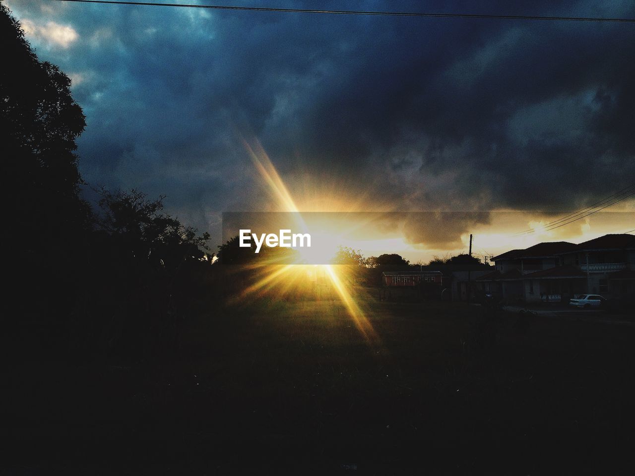 Scenic view of sunrise in city against cloudy sky