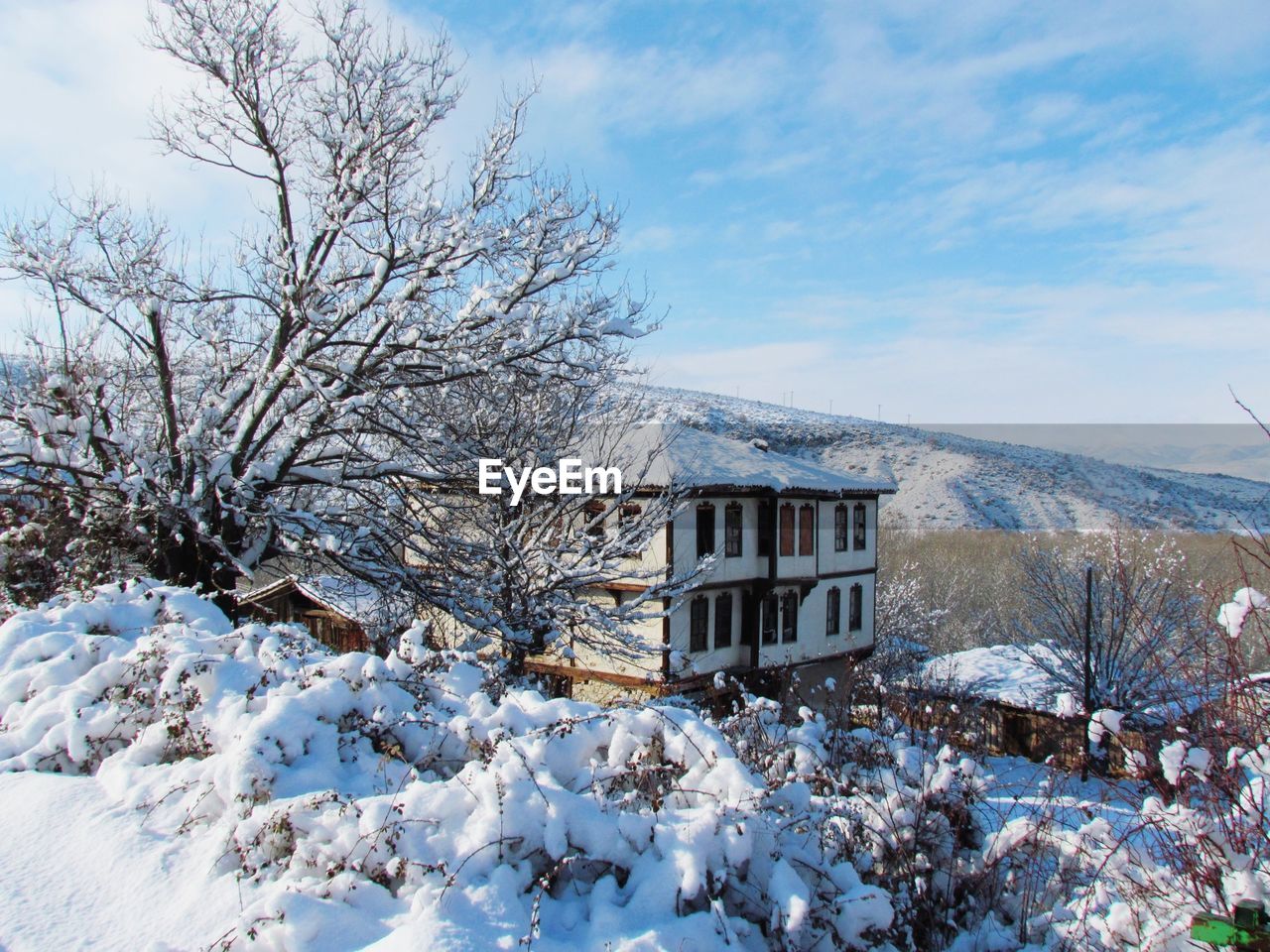 SNOW COVERED HOUSE AGAINST SKY