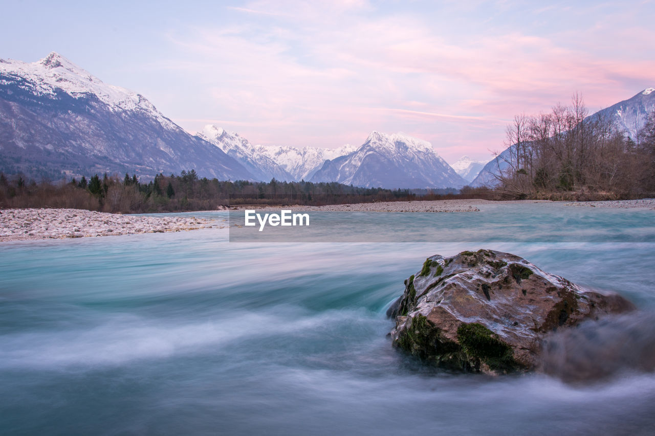 Scenic view of river and snowcapped mountains during winter