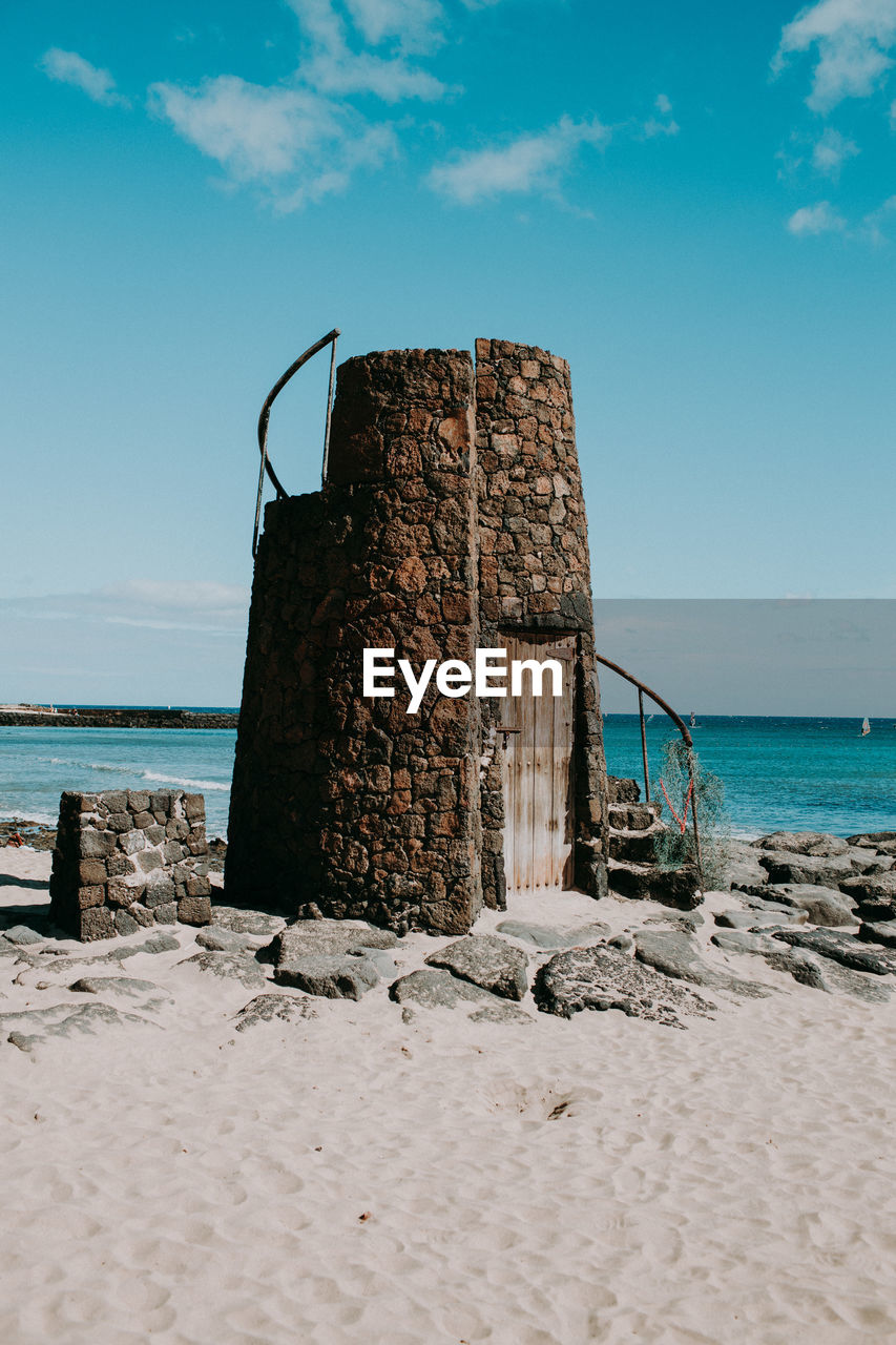 Built structure on beach against sky