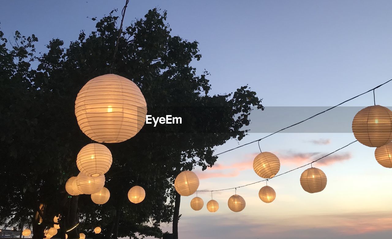 LOW ANGLE VIEW OF LANTERNS HANGING AGAINST SKY