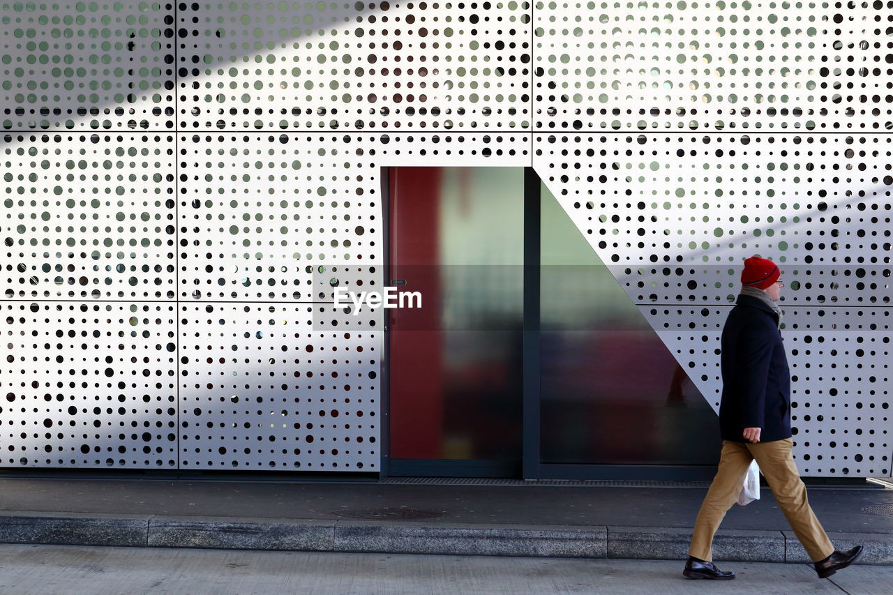 FULL LENGTH OF A MAN STANDING IN FRONT OF OFFICE